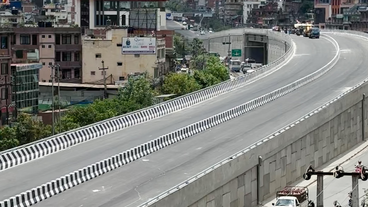Prime Minister KP Sharma Oli inaugurating the newly completed Gwarko Overpass in Lalitpur, with vehicles using the overpass and officials and locals observing the event.