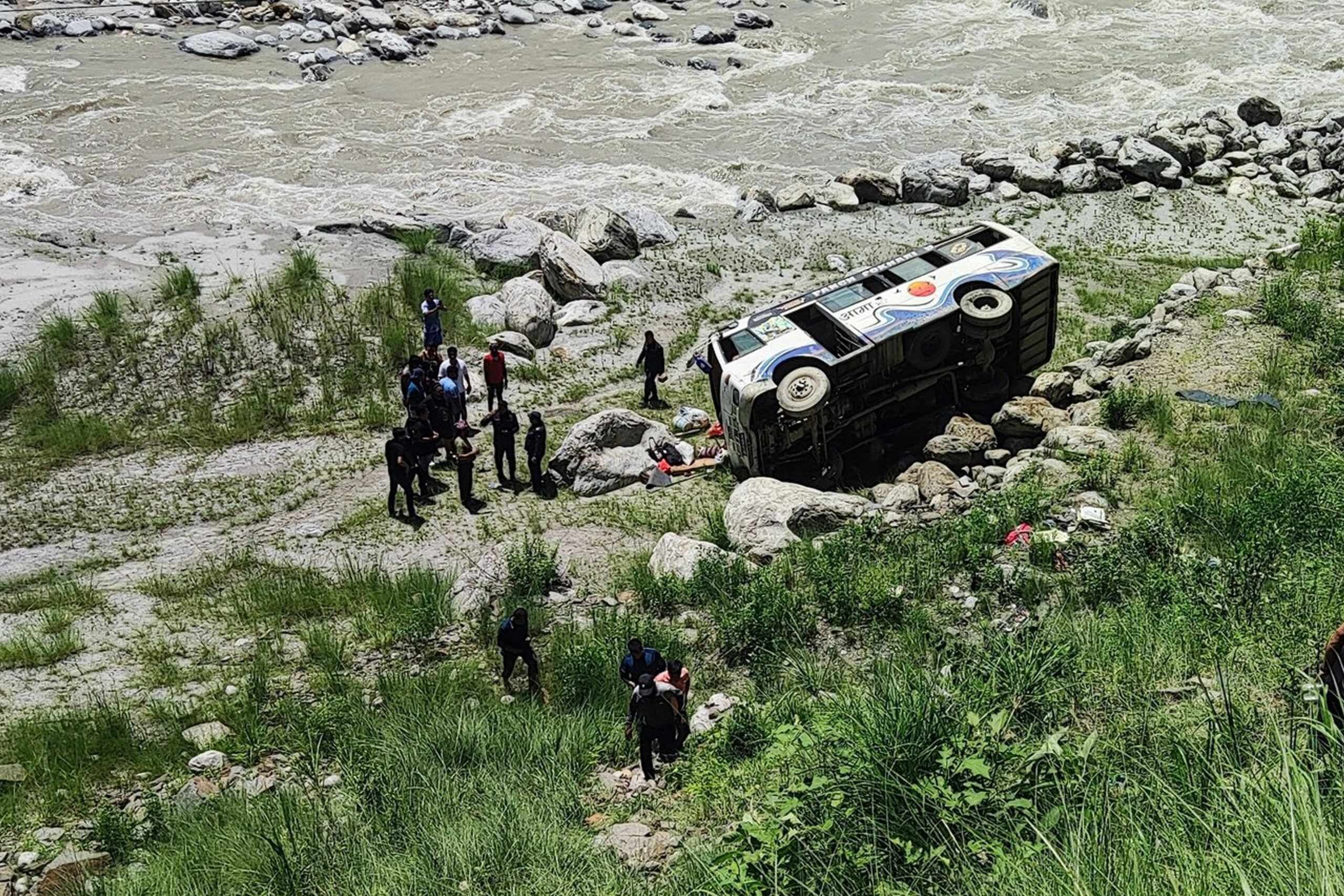 Wrecked passenger bus lying near the banks of the Indrawati River in Melamchi, Sindhupalchok, after veering off the road.