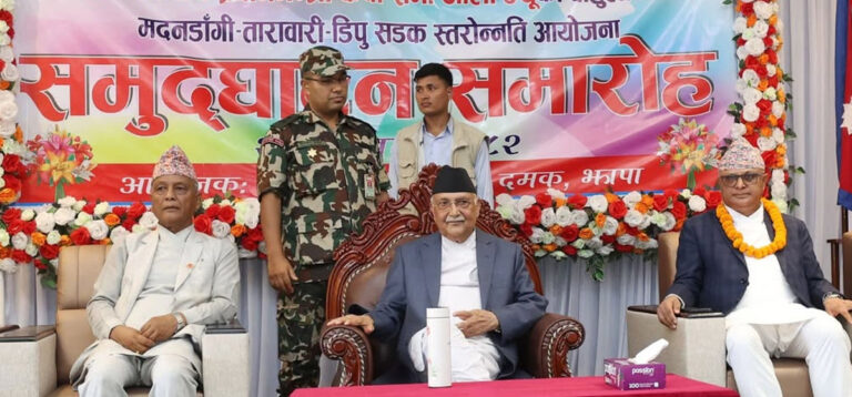 Prime Minister KP Sharma Oli speaking at the inauguration of the Madandangi–Tarabari–Dipu road project in Damak, Jhapa, alongside government officials including Minister Devendra Dahal and Koshi Province Chief Minister Hikmat Kumar Karki.