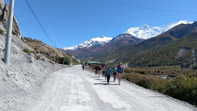 Foreign and Nepali trekkers walking along the Annapurna Circuit in Manang after the monsoon, as tourism revives with clear skies and calm weather.