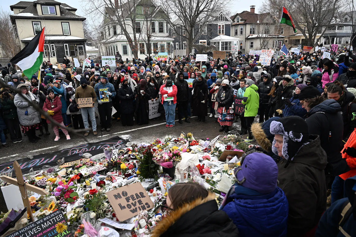 Protesters gather in southern Minneapolis holding signs against U.S. immigration enforcement following the fatal shooting of a woman by a federal agent.
