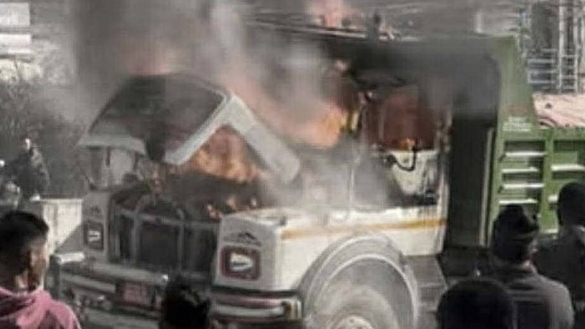 Burned tipper truck on the Araniko Highway in Banepa after a fatal collision with a scooter, as police secure the area.
