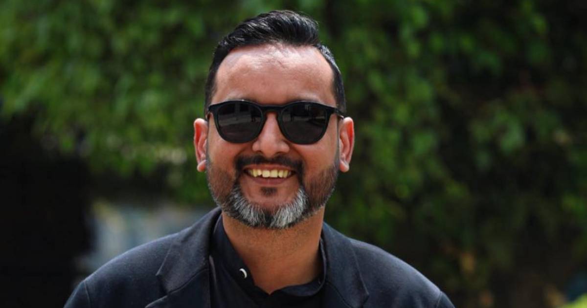 Asim Shah smiling outdoors wearing sunglasses, Nepal political advisor portrait