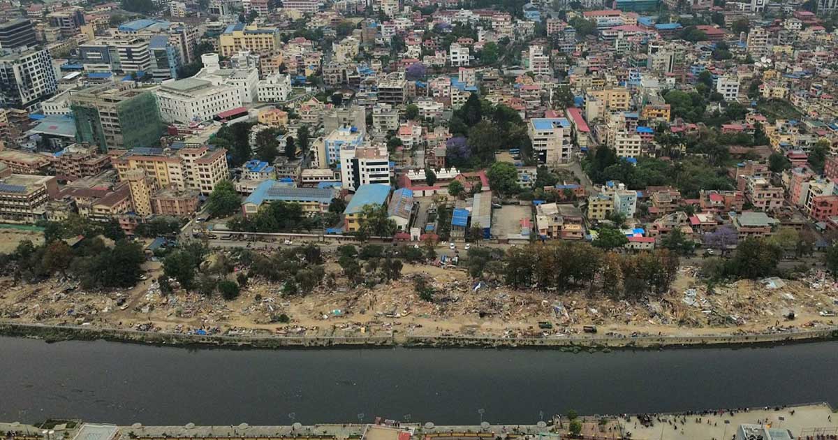 Kathmandu squatter settlements eviction aftermath along riverbank with demolished houses and cleared land