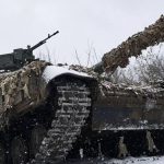 Russian tank with camouflage moves through snowy battlefield during Ukraine war as tensions rise over foreign fighters