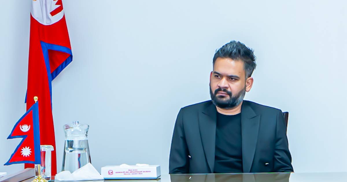 Balen Shah seated at a desk with Nepal flag behind during discussion on unions and politics