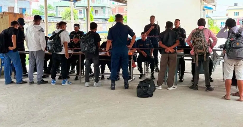 Nepali returnees gathered at a police screening and registration desk in Bhairahawa