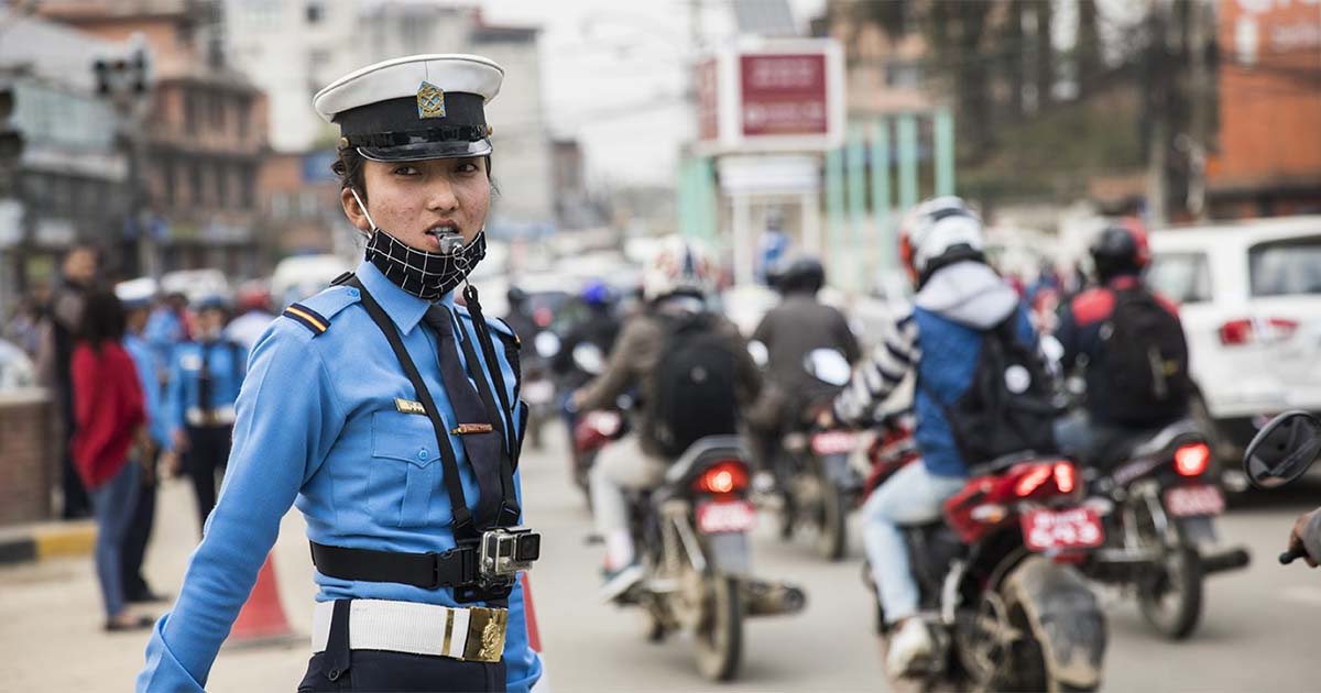Kathmandu traffic police officer monitoring vehicles on a busy city road