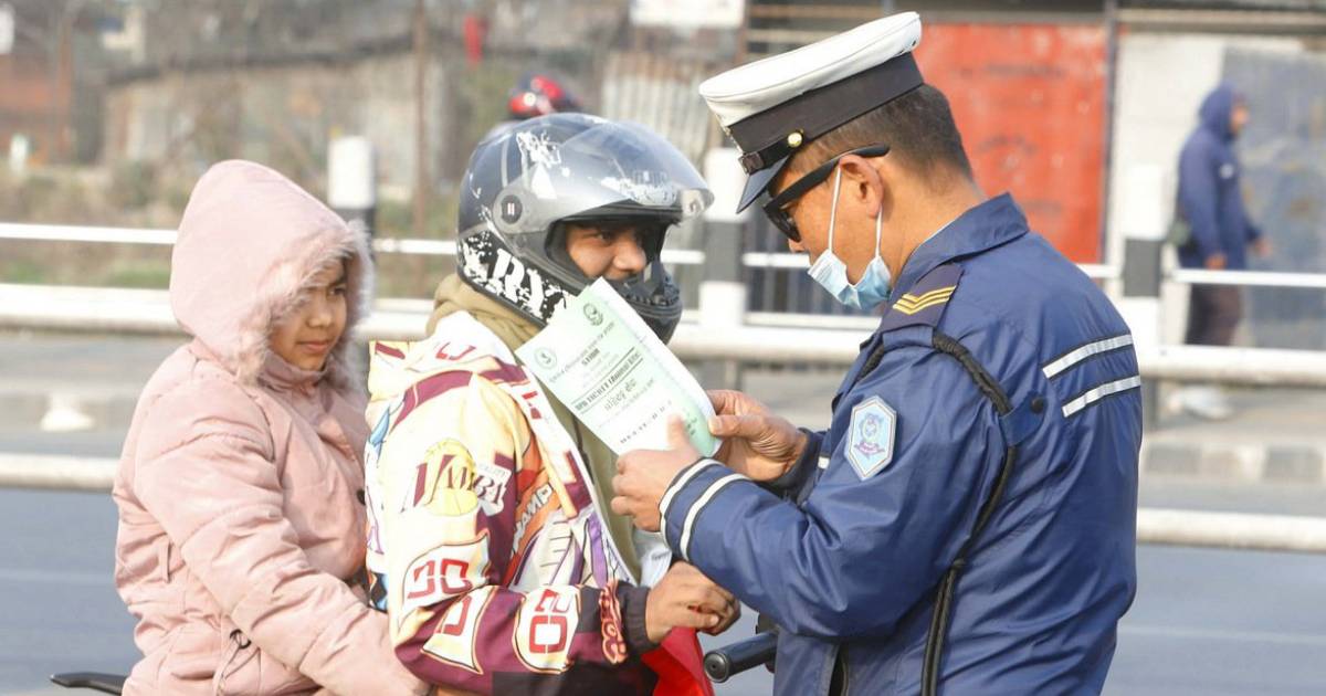 Kathmandu traffic police officer checking documents of motorcycle riders during a traffic inspection
