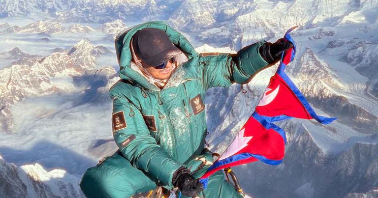 Mingma David Sherpa holding Nepal’s flag during his Everest summit climb