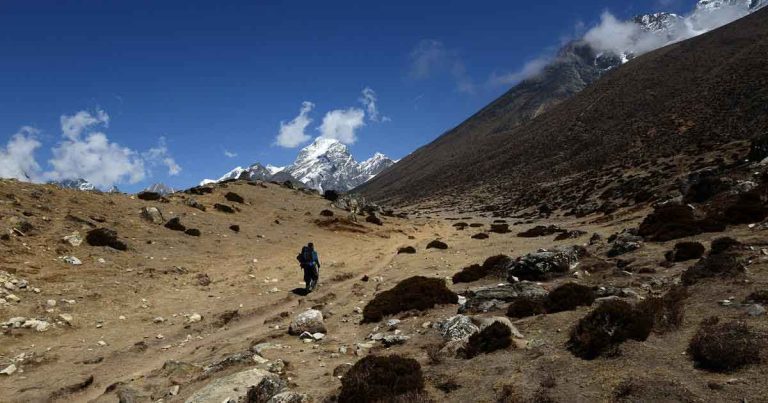 Trekker walking through Nepal’s Himalayan region amid changing climate conditions