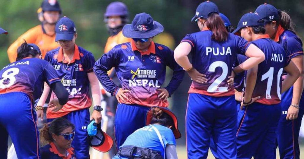 Nepal women's cricket players gather on the field during a match in Malaysia