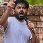 Abhijeet Dipke speaking into a microphone while addressing a gathering in Delhi
