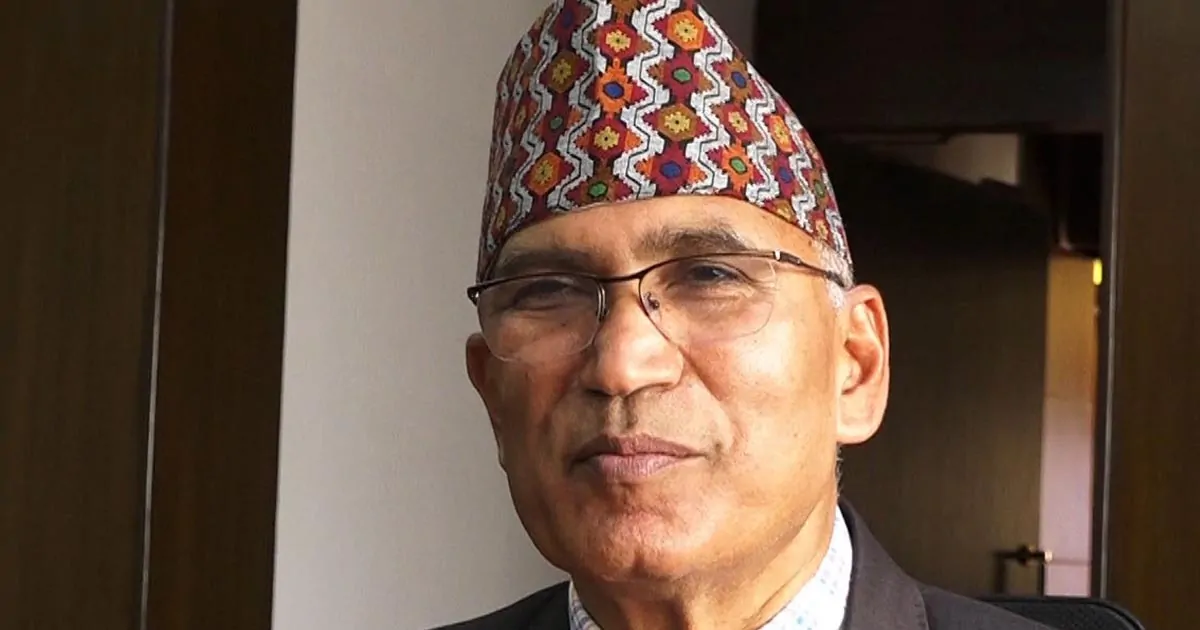 Bishnu Paudel wearing a traditional Nepali topi during an indoor portrait photograph