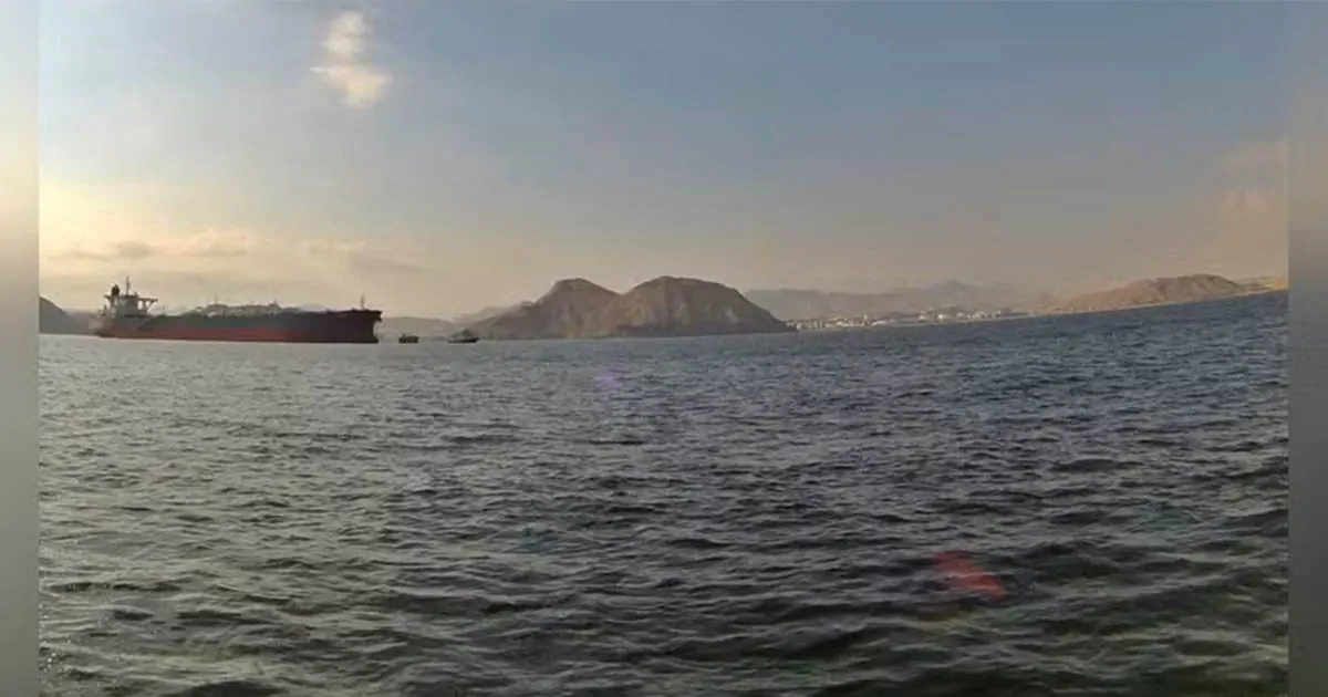 Oil tanker anchored off the coast near Oman with mountains visible across the Gulf waters