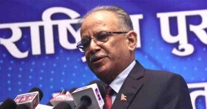 Pushpa Kamal Dahal Prachanda speaking at a public discussion program with microphones on stage