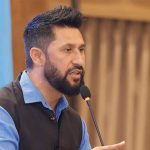 Rabi Lamichhane speaking into a microphone during a party gathering