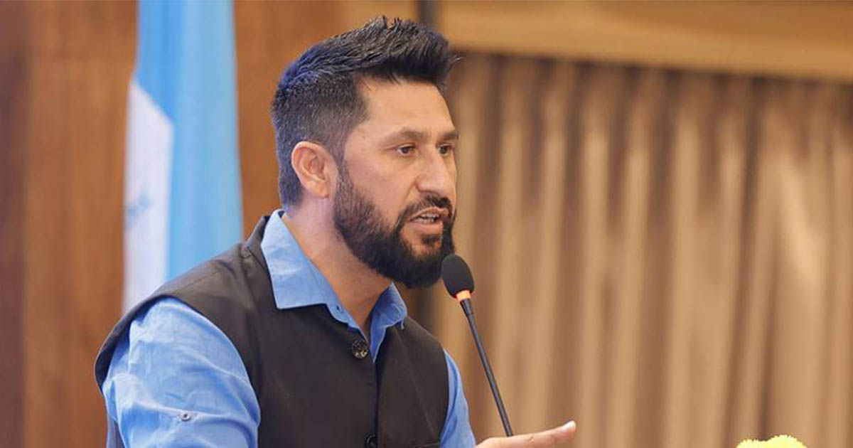 Rabi Lamichhane speaking into a microphone during a party gathering