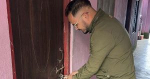 A man locking the door of the RSP district office in Dailekh during a party dispute