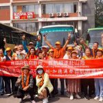 Chinese tourists pose with a welcome banner after arriving in Kathmandu on the first Shenzhen flight