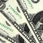 Close-up view of one US dollar banknotes arranged in an overlapping pattern