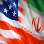 Blurred US and Iranian flags displayed side by side in a symbolic image