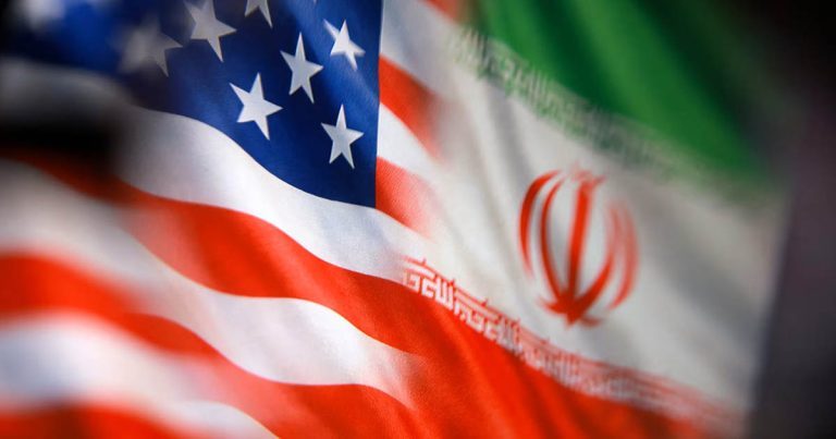 Blurred US and Iranian flags displayed side by side in a symbolic image