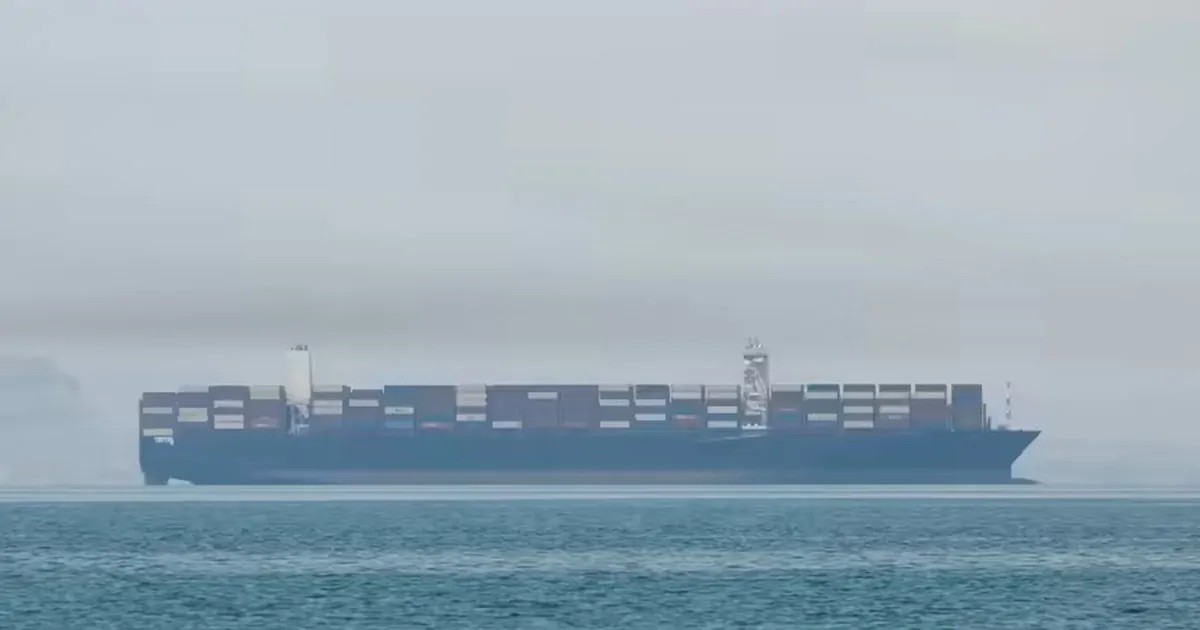 Container ship sailing across calm waters.