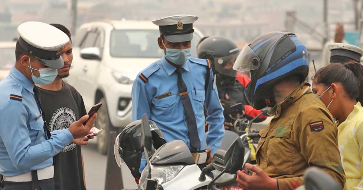 Traffic police officers inspect a motorcyclist during a roadside check in Kathmandu Valley.