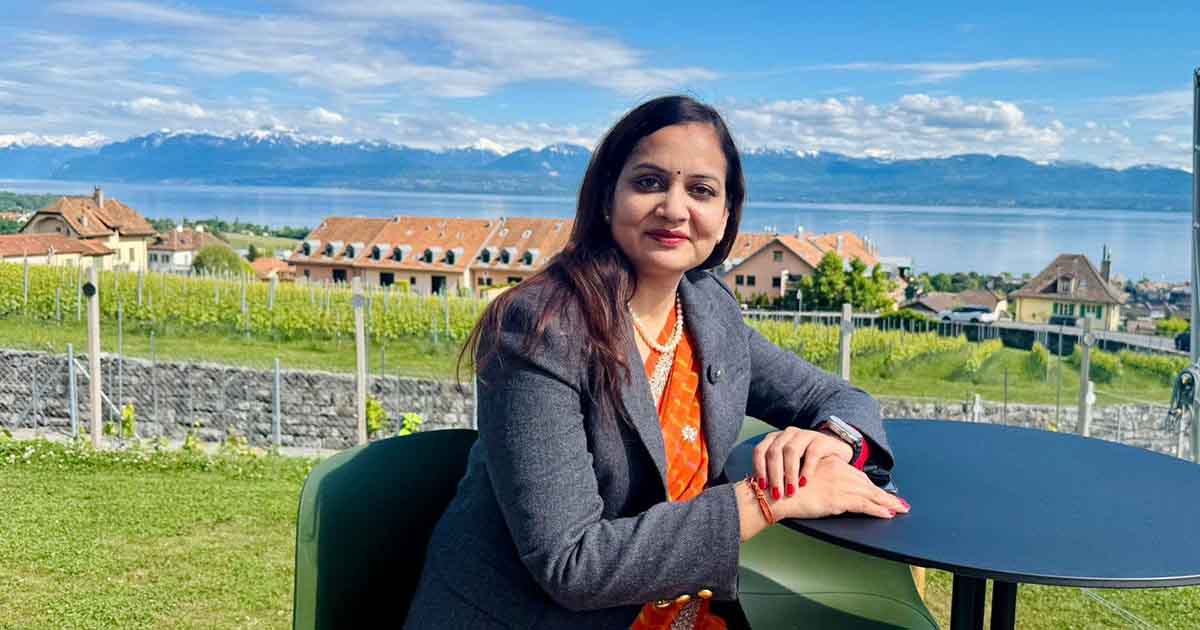 Nisha Mehta seated outdoors by a lake
