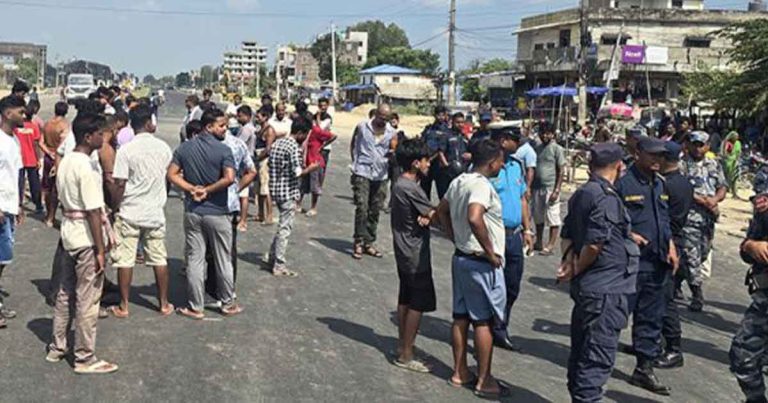 Protesters and police gathered on a road in Siraha